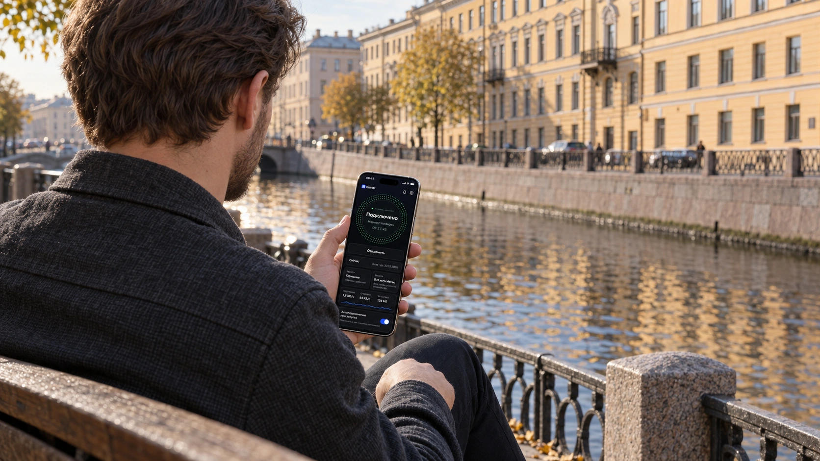 Мужчина со спины сидит на скамейке у петербургского канала и держит iPhone 17 Pro с приложением 8Tunnel.